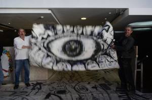 Finalizada la actividad se hizo "la Gran Muro de Berlín": todo el mundo se llevó un pedazo del Mural Colectivo y ni una manchita quedó en el Sindicato Regional de Luz y Fuerza. En la foto el artista Luis Silva y Mario Rivas agitando la bandera de El Ojo con Dientes. (foto Carola Murúa)